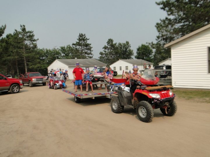 Fourth of July parade with ATV, float, and patriotic decorations