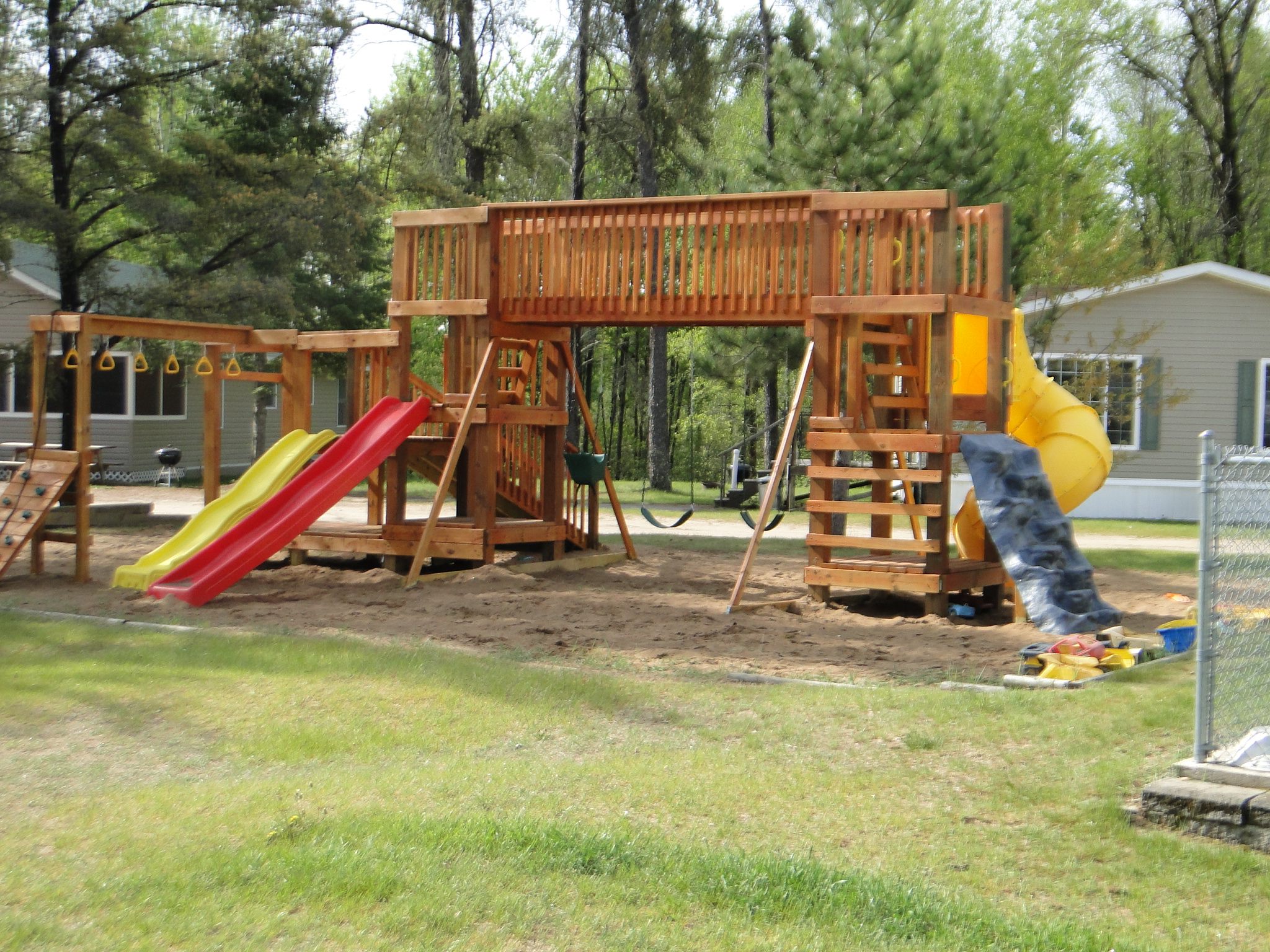 Large wooden backyard playground with slides and swings