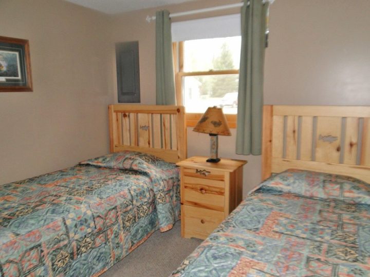 Rustic cabin bedroom with two beds and pine furniture