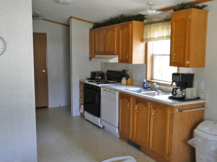 Small kitchen with oak cabinets, gas stove, and dishwasher