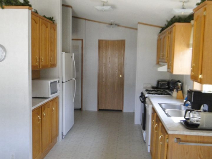 Galley kitchen with oak cabinets and white appliances