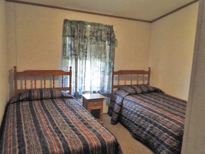 Small bedroom with two beds and wooden headboards