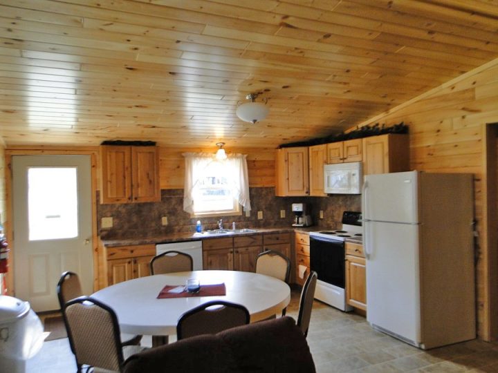 Cozy log cabin kitchen and dining area with wood paneling