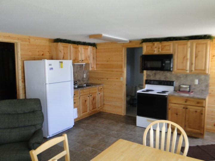 Rustic log cabin kitchen with pine cabinets and appliances