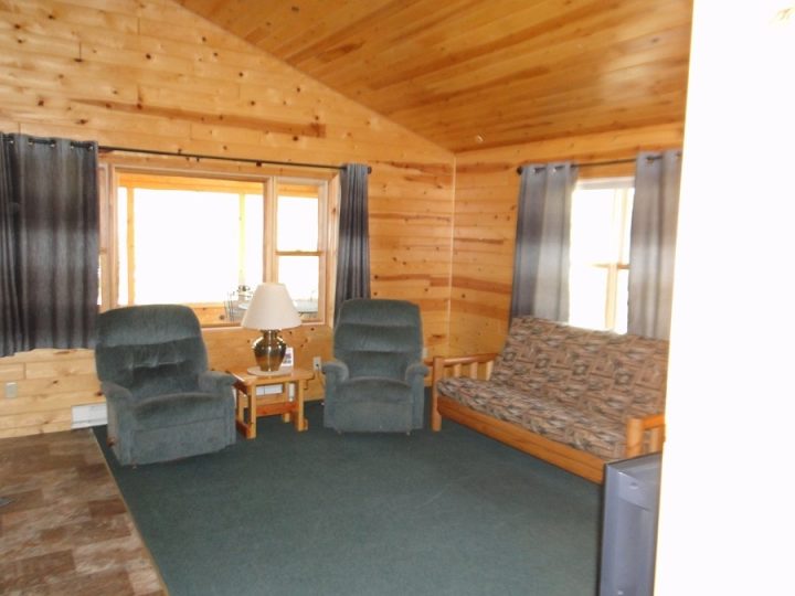 Cozy rustic cabin living room with armchairs and futon