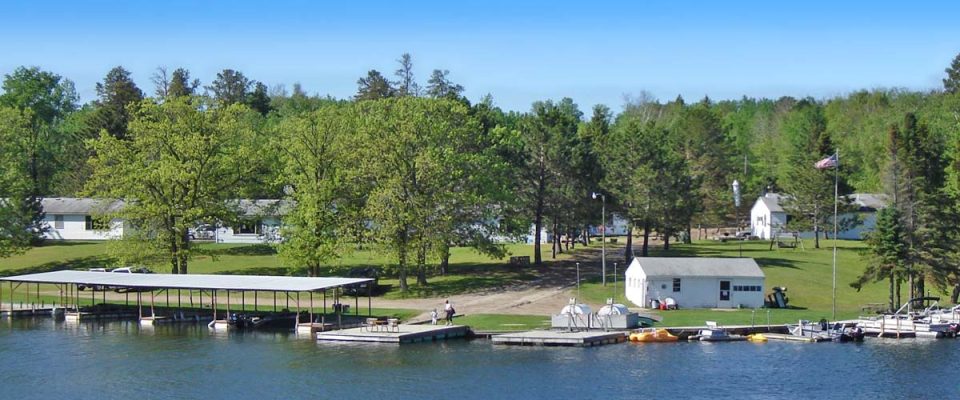 Lakeside resort with docks, boats, and green trees