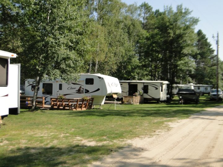 RV campground with multiple trailers parked among trees